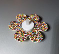 a button with sprinkles on it sitting on top of a white surface