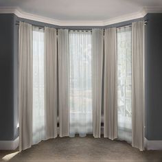 an empty room with white curtains on the windowsills and carpeted flooring