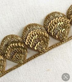 three pieces of gold filigrees on a white surface