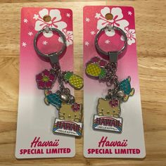 two key chains with hawaii themed charms on them