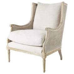 an upholstered chair with white linen and wicker