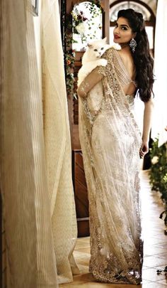 a woman in a white sari holding a dog