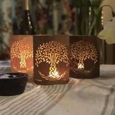 three lit candles sitting on top of a table