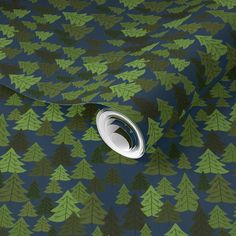 a blue and green wallpaper with trees printed on the fabric, which has a white circle at the center