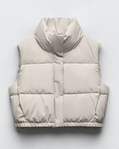 Transition into Spring with our puffer vest, featuring a luxurious soft leather-like feel and dual closure options. The button front and zipper closure offer versatility and style, while the quilted design provides warmth and comfort. Perfect for layering over sweaters or long-sleeve shirts, this vest combines both fashion and function for a chic and cozy look. CONTENT + CARE Polyester/Polyurethane Machine wash SIZE + FIT True to size Fitted Modeled in size Small Mini Puffer Vest, Womans Vest, Cream Puffer Vest, Xmas Gift Guide, Cropped Puffer Vest, Beige Puffer, Bubble Vest, Girls Puffer Vest, Vest Puffer