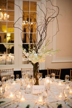 the centerpieces are decorated with branches and flowers