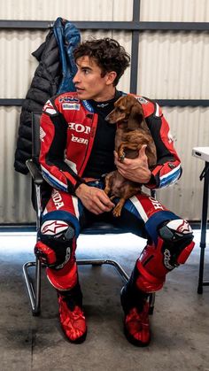 a man sitting in a chair holding a dog