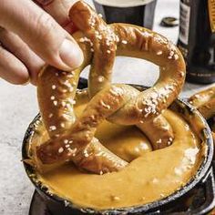 a person is dipping pretzels into some sauce