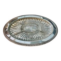 an oval glass plate with silver trimmings on the edge and bottom, set against a white background