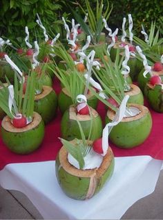 there are many coconuts that have been decorated with flowers and leaves on the table