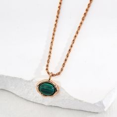 Crafted from premium 925 sterling silver and finished with a lustrous 14k gold plating, this necklace exudes refined sophistication. The centerpiece is a captivating malachite stone, a semi-precious gem known for its rich green hues and unique, swirling patterns. This necklace embodies the perfect balance of elegance and simplicity. Wear it alone for a chic, understated look, or layer it with other delicate chains and pendants to create a striking, multi-dimensional style. Whether you're dressin Luxury Malachite Necklaces For Gifts, Oval Malachite Necklace As Gift, May Birthstone Necklace With Polished Round Pendant, Gold Malachite Round Necklaces, Gold Malachite Necklace As Gift, Elegant Malachite Pendant Necklace, Gold Malachite Round Necklace, Elegant Yellow Gold Malachite Necklace, Gold Malachite Necklace For May Birthstone