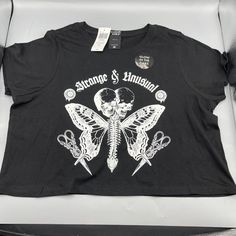 Cosmic Aura Strange & Unusual Glow-In-The-Dark Crop T-Shirt Small Something Strange And Unusual Is Fluttering Into Your Wardrobe! Turns Some Heads With This Tee, Featuring A Butterfly Creature With A Spinal Center And Two Skulls, Plus "Strange & Unusual" In A Gothic Font Up Top. Wander Into The Dark To Watch This Tee Glow! * 100% Cotton * Wash Cold; Dry Low * Length: 17" * Glows In The Dark * Imported Edgy Fitted T-shirt For Music Festival, Fitted Grunge Tops With Graphic Design, Fitted Punk Tops With Graphic Design, Edgy Halloween Graphic Print Tops, Fitted Graphic Design Top For Concert, Fitted Trendy T-shirt With Skull Print, Edgy Halloween Graphic Tops, Fitted Graphic Print T-shirt For Festival, Alternative Fitted Top With Graphic Print