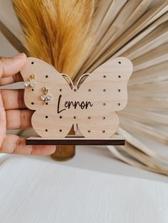 a person holding a wooden butterfly with the word lemon on it