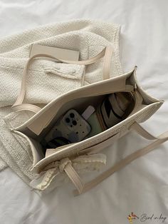 an open purse sitting on top of a bed