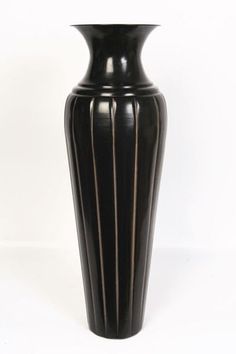 a large black vase sitting on top of a white table