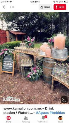 a bunch of buckets filled with flowers sitting on top of a wooden table next to a sign