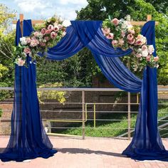 an outdoor ceremony with blue drapes and flowers