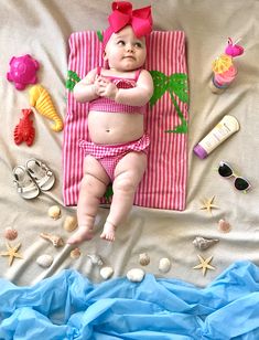 a baby laying on top of a pink towel