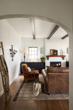 a living room filled with furniture and a fire place next to a wall mounted clock