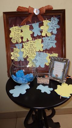 a black table topped with a bowl filled with blue and yellow paper cut out flowers