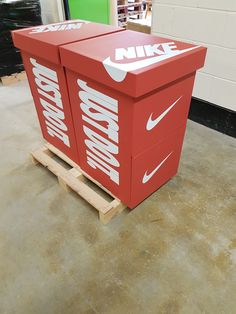 two red nike boxes sitting on top of pallets