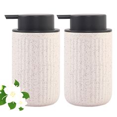 two white ceramic containers with black lids are shown next to each other on a white background