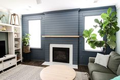 a living room with a couch, coffee table and fireplace in it's center