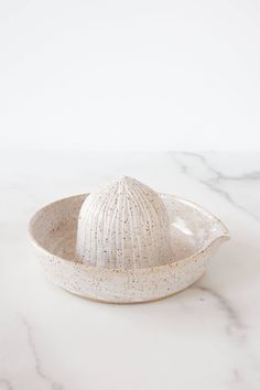 a white bowl sitting on top of a marble counter