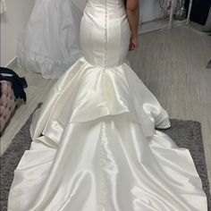 a woman standing in front of a mirror wearing a wedding dress