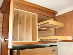 an open cabinet door in a kitchen next to a stove top oven with drawers on each side