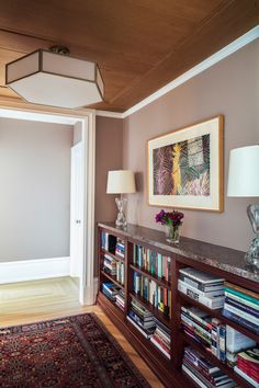 a living room with a book shelf filled with lots of books next to a lamp