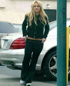 a woman standing in front of a parking meter