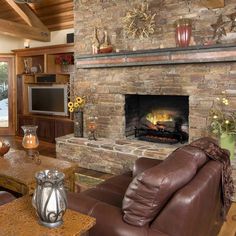 a living room filled with furniture and a fire place in front of a stone fireplace