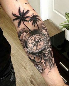 a man's arm with a compass and palm trees on it