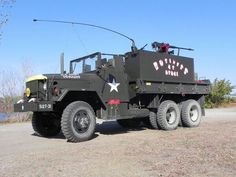 an army truck parked on top of a dirt field