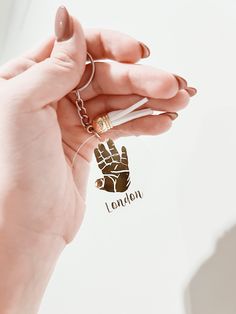 a person holding a small piece of metal in their hand with the word london on it