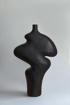 a black vase sitting on top of a white table