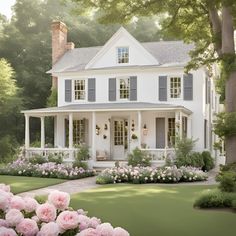 a large white house surrounded by flowers and trees