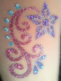 a woman's thigh with glitter tattoos on it