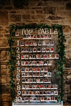 a table topped with lots of photos next to a brick wall