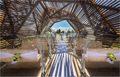 the inside of a wooden structure with white linens and flowers in vases on it