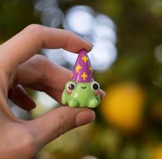 a hand holding a small toy with a party hat on