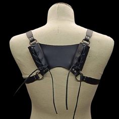 Inspired by the battle-ready gear of ancient Norse warriors, this double-sword back harness is a true masterpiece. Crafted with precision and an unwavering commitment to authenticity, it pays homage to the fearsome warriors of old while catering to the needs of contemporary enthusiasts. The harness features a rugged leather construction. The supple yet durable leather ensures your weapon is not only securely housed but also displayed with pride. The adjustable leather straps ensure a comfortable Gothic Strapped Harness For Cosplay, Strapped Gothic Harness For Cosplay, Adjustable Strapped Harness For Cosplay, Gothic Harness For Cosplay, Gothic Black Harness For Cosplay, Black Gothic Harness For Cosplay, Gothic Black Harness With Straps, Black Gothic Harness With Straps, Adjustable Strapped Gothic Harness