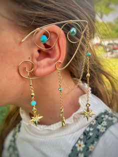 a close up of a person wearing ear rings with stars and beads attached to them