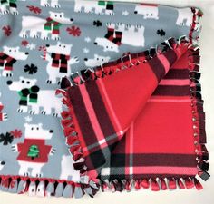 two red and gray plaid blankets with polar bears on them, one is folded over the other