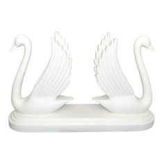 two white swans sitting on top of each other