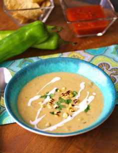 a blue bowl filled with soup and garnished with corn on the cob