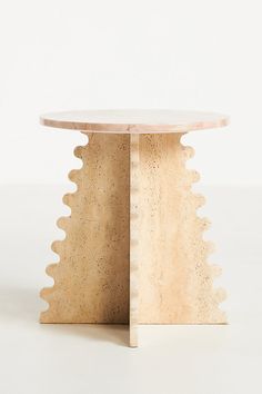 a round table with scalloped edges and a wooden base, on a white background