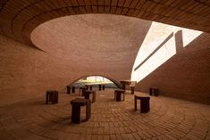 the inside of a brick building with benches and tables