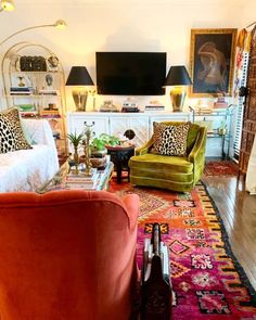 a living room filled with furniture and a flat screen tv on top of a wall